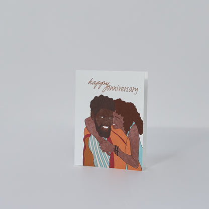 happy anniversary greeting card with illustration of black couple the woman with an afro wearing a blue dress with her arms  around the man with a beard wearing an orange jacket both smiling at each other